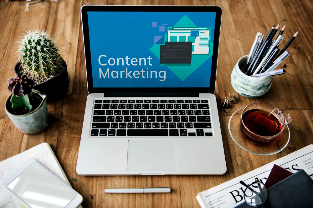 Content marketing written on the screen of a laptop sitting on a wooden desk