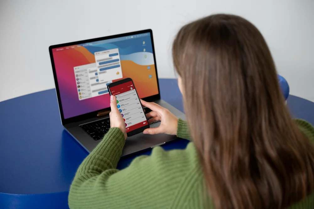 A woman sitting at a desk showing a mobile friendly website